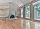 Cozy living room with a fireplace, hardwood floors, and large windows with wooded views at 3771 Club Nw Dr, Kennesaw, GA 30144