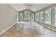 Bright sunroom with tile flooring, a ceiling fan, and large windows with wooded views at 3771 Club Nw Dr, Kennesaw, GA 30144