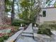 Landscaped stone walkway leading to a home, surrounded by lush trees and foliage in a serene setting at 3771 Club Nw Dr, Kennesaw, GA 30144