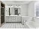 Bright bathroom features double sinks, tile flooring, and a large soaking tub at 630 Dana Pointe Ct, Lawrenceville, GA 30045