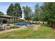 Backyard showcasing an inground pool, spacious patio, and mature trees for privacy at 630 Dana Pointe Ct, Lawrenceville, GA 30045