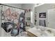 Bright bathroom featuring a vanity, toilet, and a shower with a stylish butterfly-themed curtain at 1258 Rocky Branch Trl, Lawrenceville, GA 30043