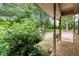 A covered back porch surrounded by lush greenery at 129 Bill Smith Dr, Canton, GA 30114