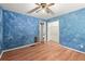 Stylish bedroom with hardwood floors, an artsy blue wall design and a closet for organized living at 129 Bill Smith Dr, Canton, GA 30114