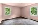 Empty pink bedroom featuring two windows that let in natural light and a unique carpet at 129 Bill Smith Dr, Canton, GA 30114