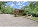 Charming brick home with a covered porch and a spacious gravel driveway, surrounded by lush greenery at 129 Bill Smith Dr, Canton, GA 30114