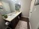Bathroom with brown vanity, modern sink, decorative rug, and framed mirror at 3915 Woodridge Way, Tucker, GA 30084