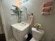 Bathroom featuring a vanity sink, arched mirror, textured walls, and fresh flowers at 3915 Woodridge Way, Tucker, GA 30084