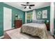 Bedroom with green walls, natural light, ceiling fan, and a floral comforter at 1630 Park Ln, Marietta, GA 30066