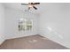 Carpeted bedroom with fan, closet, and a large window at 1745 Habersham Marina Rd, Cumming, GA 30041