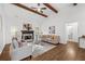 Bright living room features a stone fireplace, beamed ceiling, and hardwood floors at 1745 Habersham Marina Rd, Cumming, GA 30041