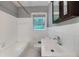 Bright bathroom features a tub, window, and vanity with dark wood medicine cabinet at 3080 Lynhurst Cir, Atlanta, GA 30311