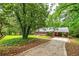 Scenic view of a brick home nestled among mature trees with a covered carport at 3080 Lynhurst Cir, Atlanta, GA 30311
