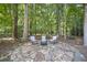 A stone patio in a wooded backyard is furnished with a three-piece wicker set at 4525 Cavallon Nw Way, Acworth, GA 30101