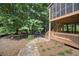 An exterior shot of a home's backyard featuring a covered patio and a stone walkway leading to an outdoor seating area at 4525 Cavallon Nw Way, Acworth, GA 30101