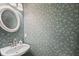 Charming powder room with leaf-patterned wallpaper and white fixtures at 4525 Cavallon Nw Way, Acworth, GA 30101