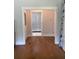 Hallway with hardwood floors leads to the bathroom with white trim at 203 Belmont Park Dr, Canton, GA 30115