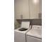 Well-equipped laundry area with front-load washer and dryer, plus storage cabinets above at 203 Belmont Park Dr, Canton, GA 30115