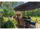 Outdoor dining area with stone fireplace, perfect for alfresco meals and entertaining in a serene backyard setting at 203 Belmont Park Dr, Canton, GA 30115