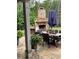 Stone outdoor fireplace on stone patio with an outdoor dining table and chairs at 203 Belmont Park Dr, Canton, GA 30115