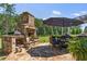 Outdoor kitchen and dining area features a stone fireplace and ample space for entertaining in the backyard at 203 Belmont Park Dr, Canton, GA 30115
