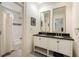 White bathroom boasts dual sinks, dark countertops, and an adjacent shower at 241 Nacoochee Nw Dr, Atlanta, GA 30305