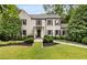 Charming two-story home with a manicured lawn, gray painted brick, and black shutters at 241 Nacoochee Nw Dr, Atlanta, GA 30305