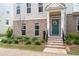 Inviting townhouse entrance with a wreath-adorned front door and charming brick detailing at 361 Watson Ave, Woodstock, GA 30189