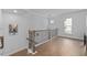 Hallway featuring hardwood floors and railing with art hanging in the hallway at 361 Watson Ave, Woodstock, GA 30189