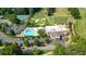 An aerial view of a clubhouse with a pool, tennis courts, and golf course on a sunny day at 11940 Mountain Laurel Dr, Roswell, GA 30075