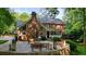 Brick home exterior with a stone patio, fire pit, and beautiful landscaping at 11940 Mountain Laurel Dr, Roswell, GA 30075