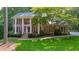 Beautiful brick home featuring a covered porch and well-manicured lawn at 11940 Mountain Laurel Dr, Roswell, GA 30075