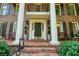 Inviting front porch with brick steps, seating, and elegant architectural details at 11940 Mountain Laurel Dr, Roswell, GA 30075