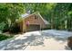 Brick home with a spacious garage and driveway, surrounded by mature landscaping at 11940 Mountain Laurel Dr, Roswell, GA 30075