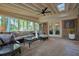 Bright sunroom with comfortable seating, brick accents, and lots of windows overlooking lush greenery at 11940 Mountain Laurel Dr, Roswell, GA 30075