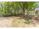 Mature trees adorn a large backyard with grass, a wooden deck, and a privacy fence at 3830 Gallant Fox Ct, Duluth, GA 30096
