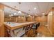 Basement bar area with an island-style bar, seating, and wood-paneled walls at 3830 Gallant Fox Ct, Duluth, GA 30096