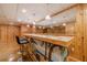Basement bar area with an island-style bar, seating, and wood-paneled walls at 3830 Gallant Fox Ct, Duluth, GA 30096