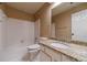 Bathroom featuring a granite countertop vanity and tile surround bathtub at 3830 Gallant Fox Ct, Duluth, GA 30096