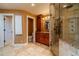 Elegant bathroom featuring travertine tile, a wood vanity, and a glass-enclosed shower at 3830 Gallant Fox Ct, Duluth, GA 30096