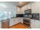 Chef's kitchen boasts stainless steel appliances, granite counters, stylish cabinetry, and natural light at 3830 Gallant Fox Ct, Duluth, GA 30096