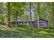 Charming home featuring dark blue painted brick and siding, lush landscaping, and a porch swing at 6878 Brandon Mill Rd, Sandy Springs, GA 30328