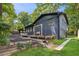 View of rear elevation showing the dark blue brick, covered porch, tiered backyard, and green lawn at 6878 Brandon Mill Rd, Sandy Springs, GA 30328
