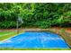 Private backyard featuring a basketball court, bordered by trees and landscaping at 265 Landfall Rd, Atlanta, GA 30328