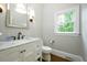 Bright powder room featuring vanity with marble countertop and decorative mirror at 265 Landfall Rd, Atlanta, GA 30328