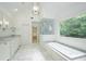 Bathroom featuring a soaking tub, glass-enclosed shower, and marble countertops at 265 Landfall Rd, Atlanta, GA 30328