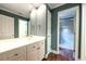 Bright bathroom featuring a white vanity, large mirror, and doorway to a tiled shower at 265 Landfall Rd, Atlanta, GA 30328
