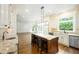 Open concept kitchen with an island, bar stools, and views into the living area at 265 Landfall Rd, Atlanta, GA 30328