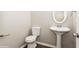 Clean powder room featuring a pedestal sink, toilet, and modern fixtures at 5612 Festival Ave, Fairburn, GA 30213