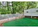 Small, fenced backyard featuring a green surface surrounded by a lattice fence and trees at 5640 Terremont Cir, Norcross, GA 30093